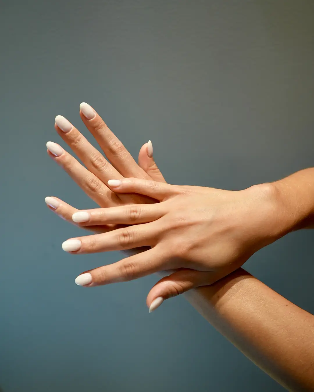 Mano con unghie color nude lattiginoso